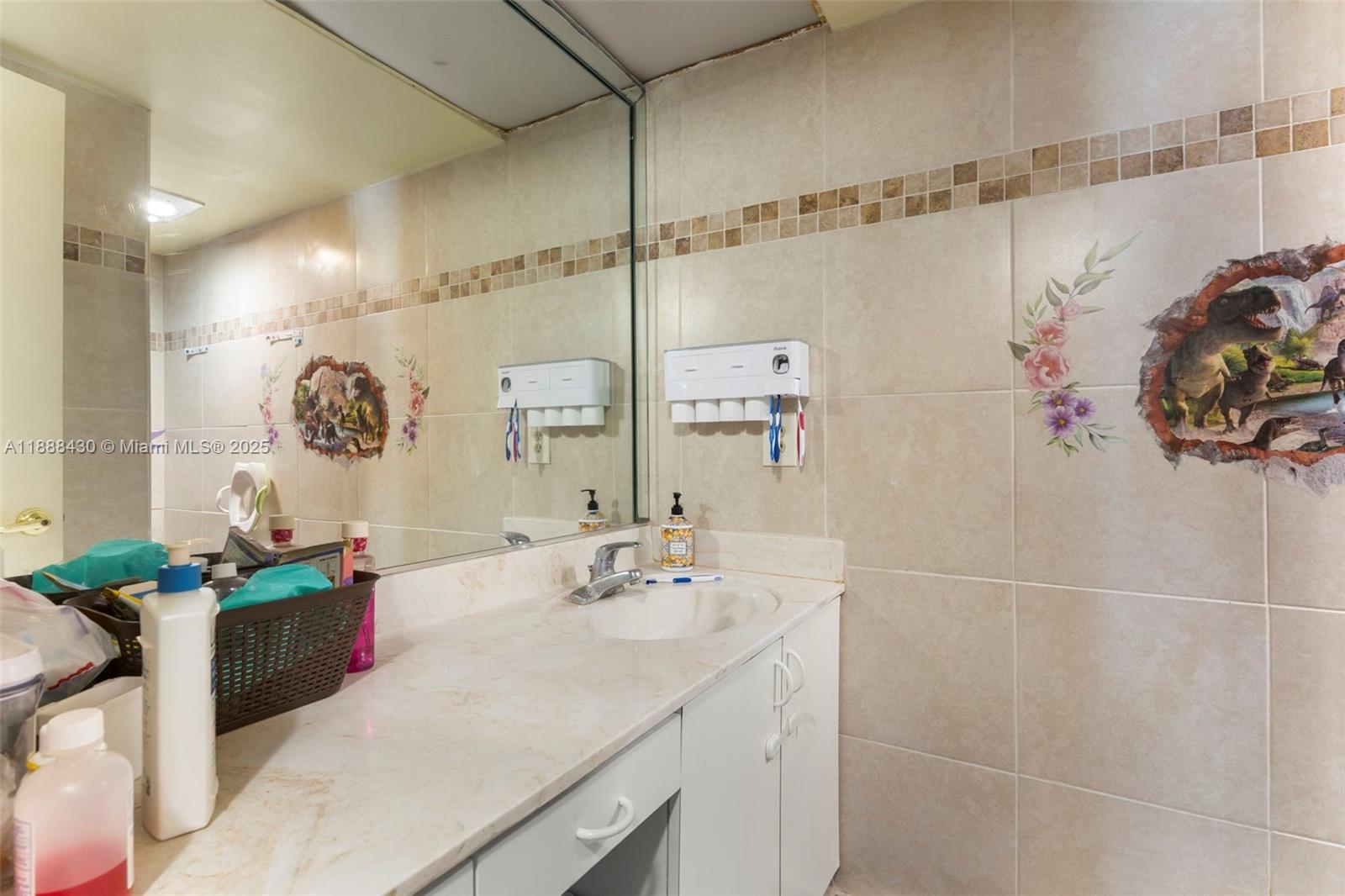 19440 Northeast 26th Avenue, Unit 53B Miami, FL 33180 - Photo 18 of 33 a bathroom with a double vanity sink mirror and shower