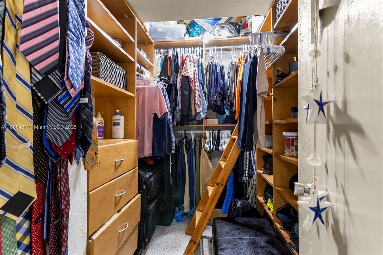 19440 Northeast 26th Avenue, Unit 53B Miami, FL 33180 - Photo 23 of 33 a view of walk in closet with clothes