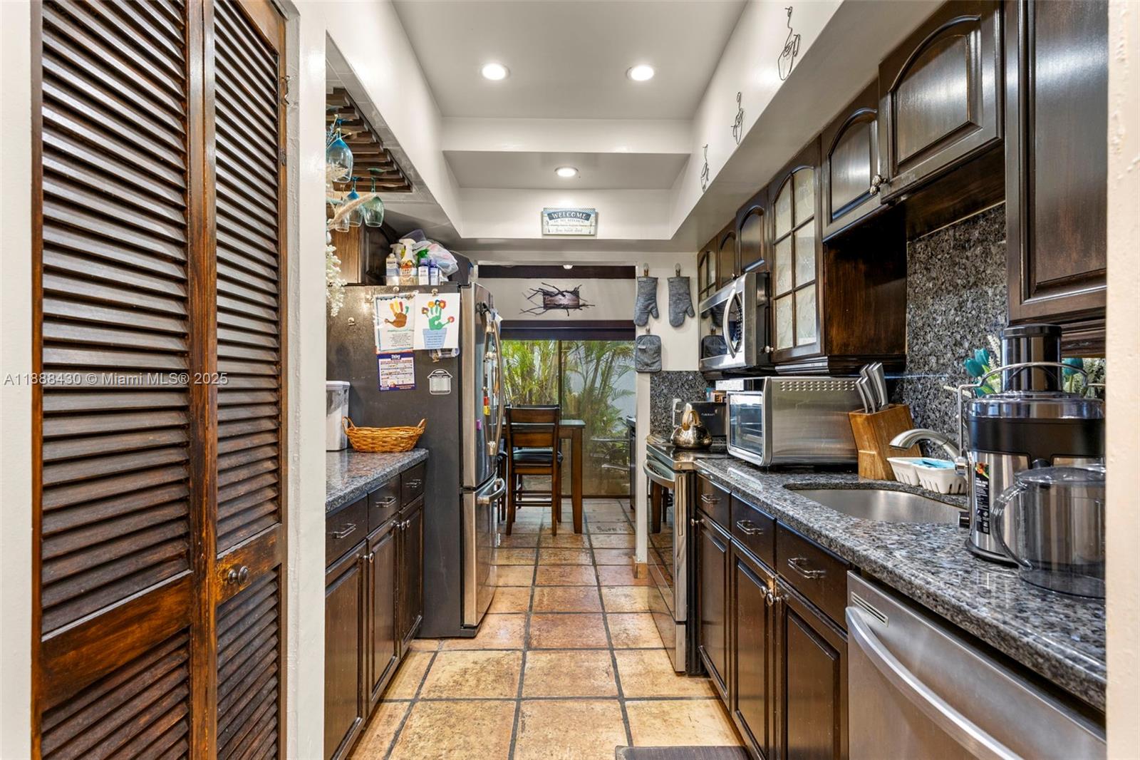19440 Northeast 26th Avenue, Unit 53B Miami, FL 33180 - Photo 8 of 33 a kitchen with granite countertop a sink and cabinets