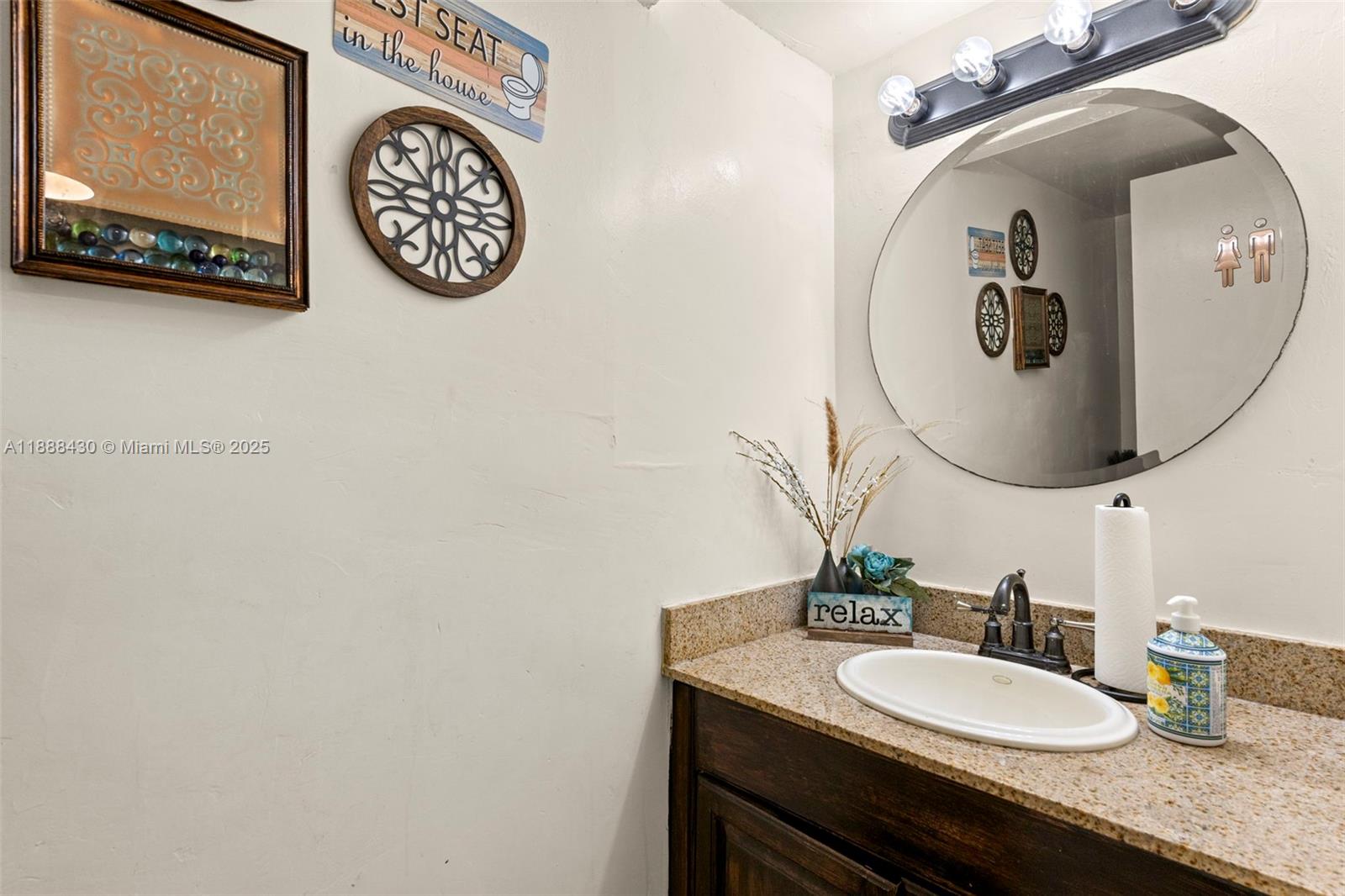 19440 Northeast 26th Avenue, Unit 53B Miami, FL 33180 - Photo 10 of 33 a bathroom with a granite countertop sink and a mirror