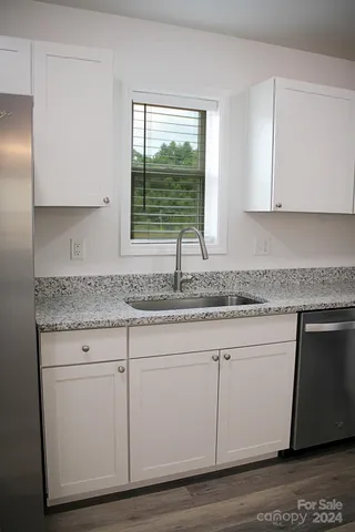 a kitchen with granite countertop cabinets and window