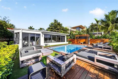 a view of a house with pool and chairs