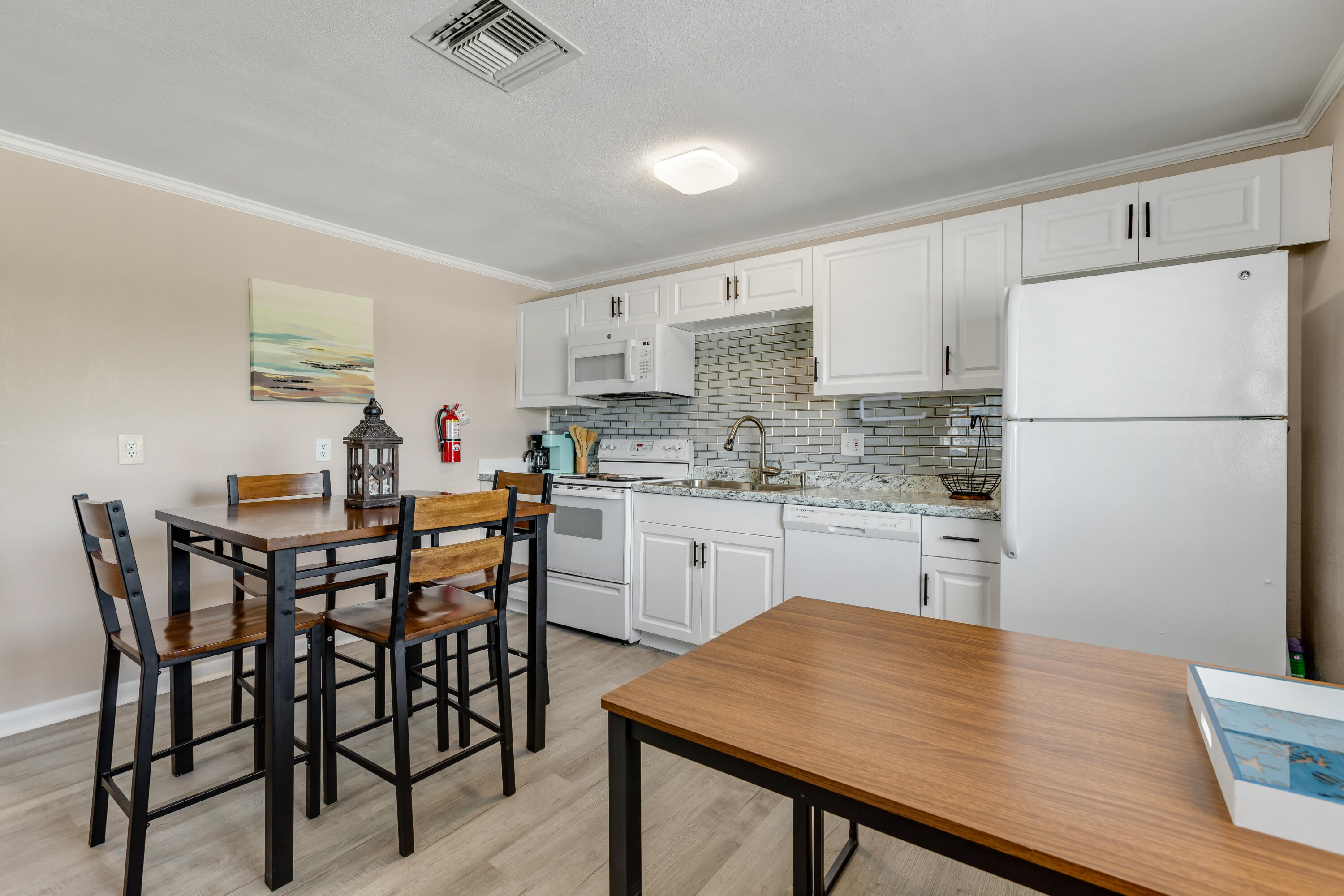 280-290 3rd Street Key Colony Beach, FL 33051 - Photo 19 of 28 a kitchen with a table chairs white stainless steel appliances and cabinets
