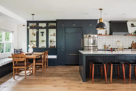 a dining room with wooden floor a chandelier a wooden table and chairs