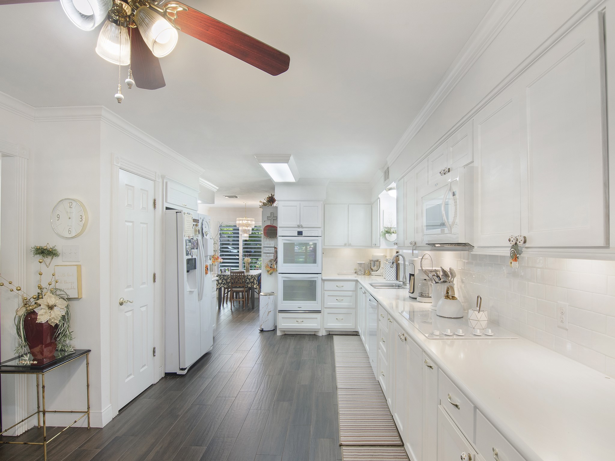 532 Raleigh Drive Conroe, TX 77302 - Photo 15 of 40 Bright and airy kitchen showcasing sparkling white quartz countertops, classic subway tile backsplash and wood-look tile flooring. The neutral, all-white palette creates a fresh feel that's both stylish and inviting.