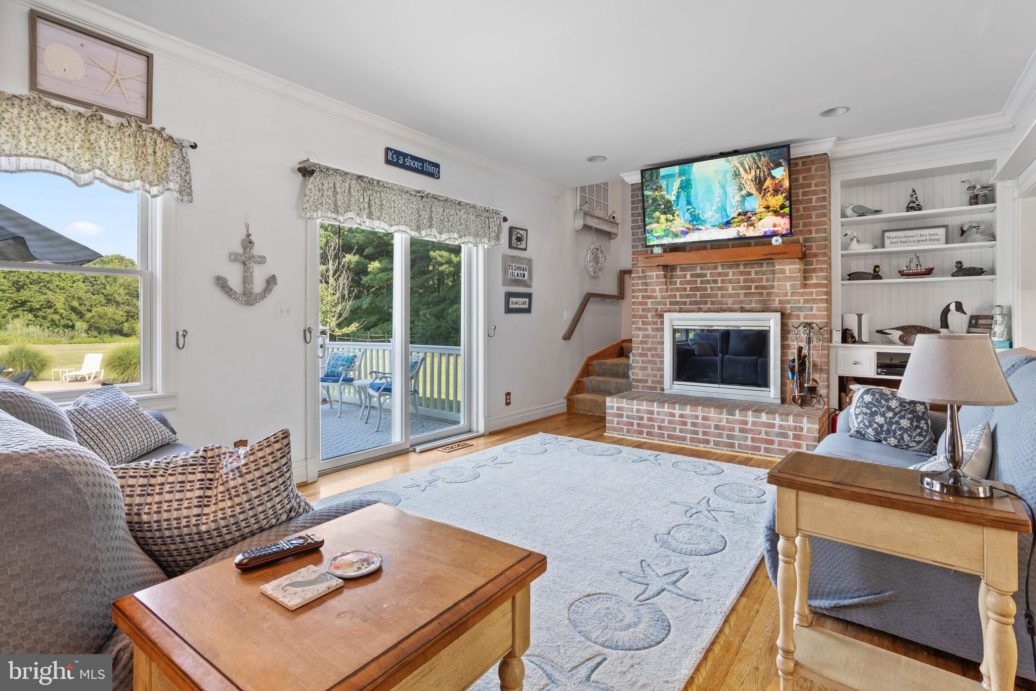 4957 Bar Neck Road Tilghman, MD 21671 - Photo 17 of 45 a living room with furniture a flat screen tv and a fireplace