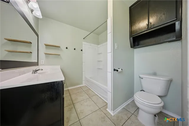 a view of an empty room with window and chandelier fan