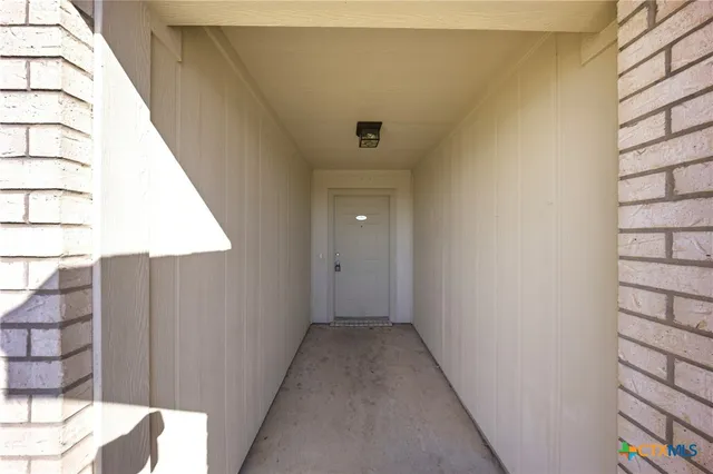a view of a hallway with wooden floor and entryway