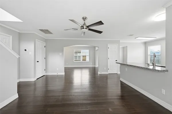 a view of an empty room with window and wooden floor