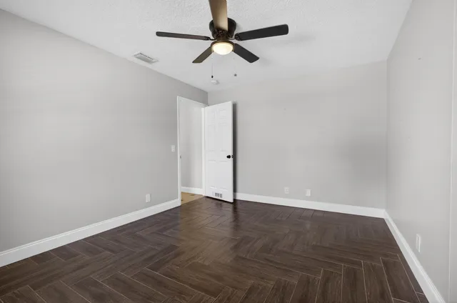 a bathroom with a granite countertop sink toilet and mirror