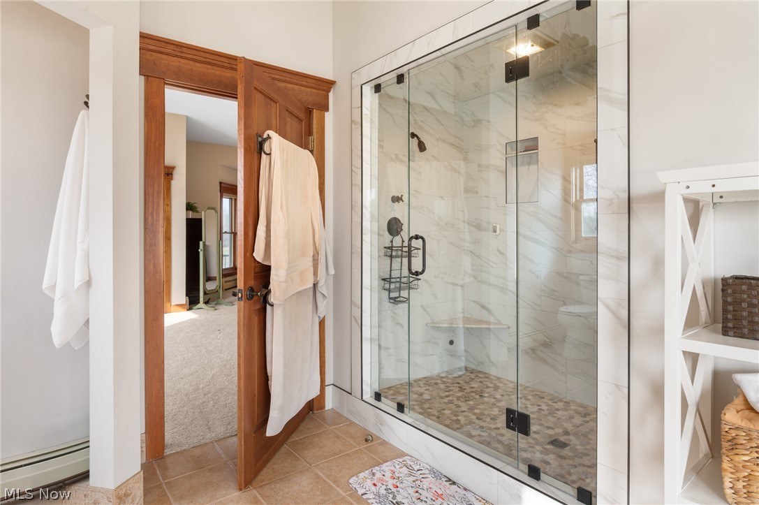 9419 Robinson Road Chardon, OH 44024 - Photo 24 of 46 Bathroom with a marble finish shower, baseboard heating, and light tile patterned floors