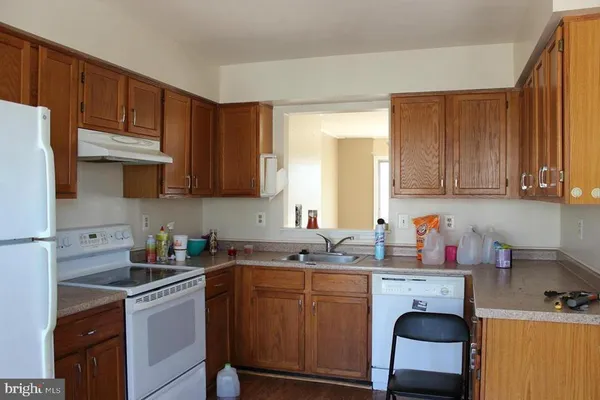 a kitchen with stainless steel appliances granite countertop a sink stove refrigerator and cabinets