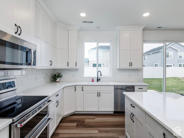 374 Ropelato Drive Nibley, UT 84321 - Photo 5 of 15 Kitchen with stainless steel appliances, dark wood-style floors, healthy amount of natural light, decorative backsplash, and recessed lighting
