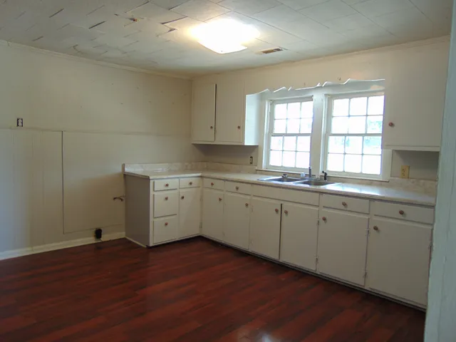 a kitchen with sink cabinets and wooden floor