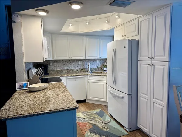 a kitchen with refrigerator and cabinets