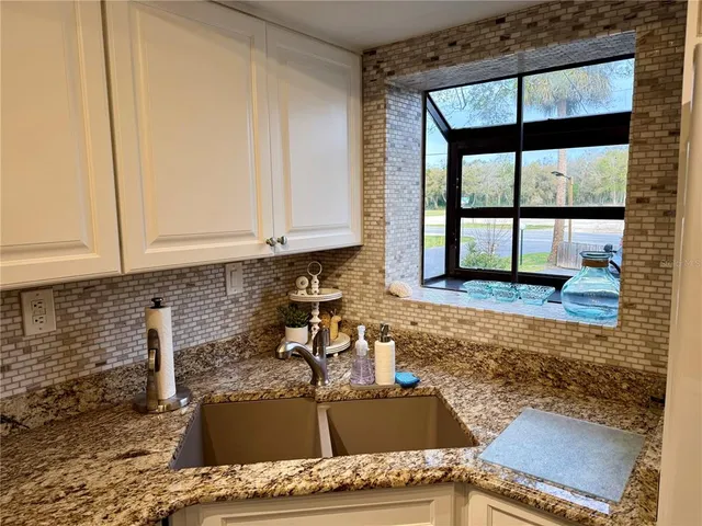 a kitchen with granite countertop a sink and a stove top oven