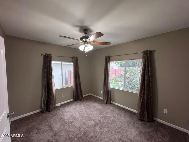 an empty room with closet and a chandelier fan