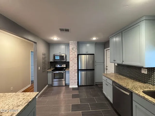 a metallic refrigerator freezer sitting in a kitchen
