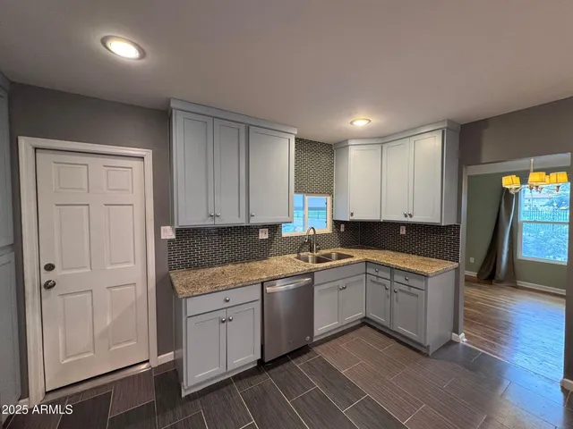 a kitchen with a sink dishwasher a refrigerator and cabinets