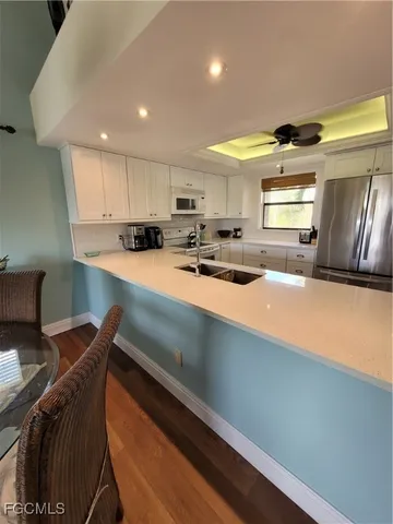 a kitchen with stainless steel appliances a sink a stove a refrigerator and cabinets