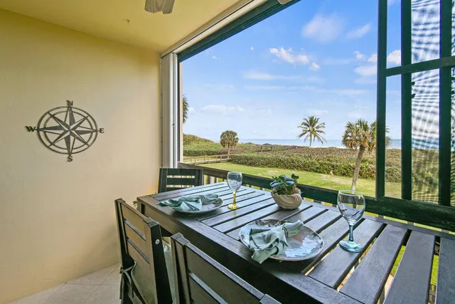 a view of a dining room with furniture a rug and a floor to ceiling window