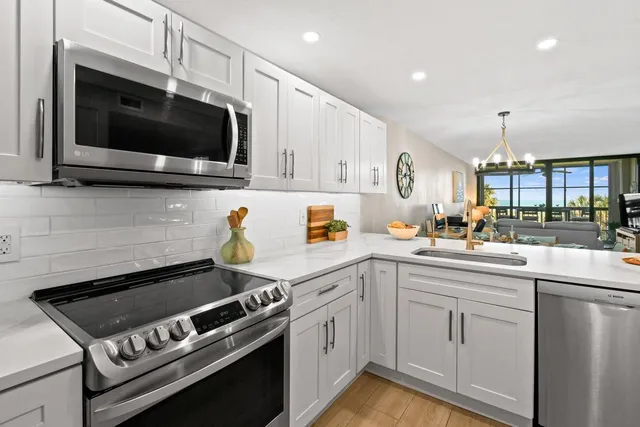 a kitchen with stainless steel appliances a sink a stove and microwave