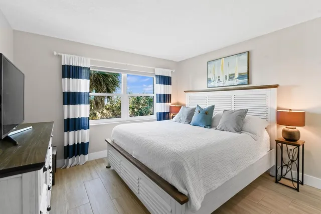 a bed room with a bed and a large window