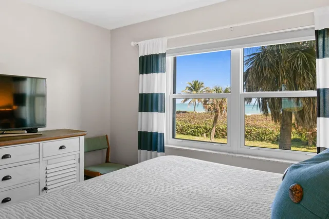 a bedroom with a bed and a flat tv screen on dresser