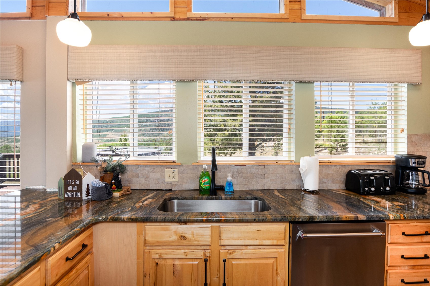 1301 Sheep Ridge Road Fairplay, CO 80440 - Photo 19 of 49 Kitchen featuring a stainless steel undermount sink, richly variegated stone countertops, natural wood cabinetry, and a stainless steel dishwasher