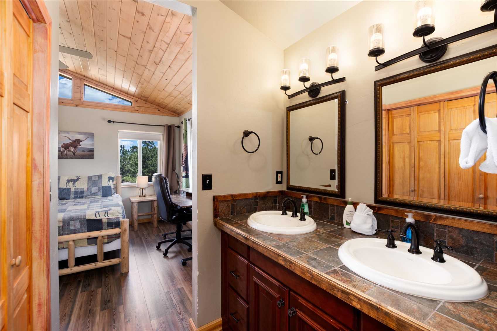 1301 Sheep Ridge Road Fairplay, CO 80440 - Photo 32 of 49 Dual vanity with dark wood cabinetry, tile countertop, and individual framed mirrors