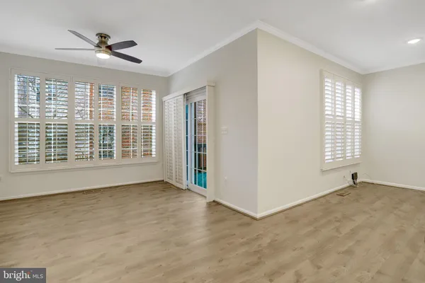 a view of a kitchen with stainless steel appliances wooden floor and windows