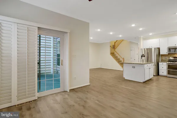 a kitchen with granite countertop white cabinets and stainless steel appliances