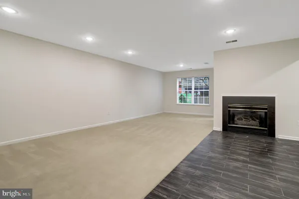 a view of empty room with a fireplace and wooden floor