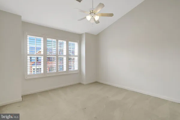 an empty room with a window and a fan