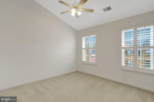 an empty room with a chandelier fan