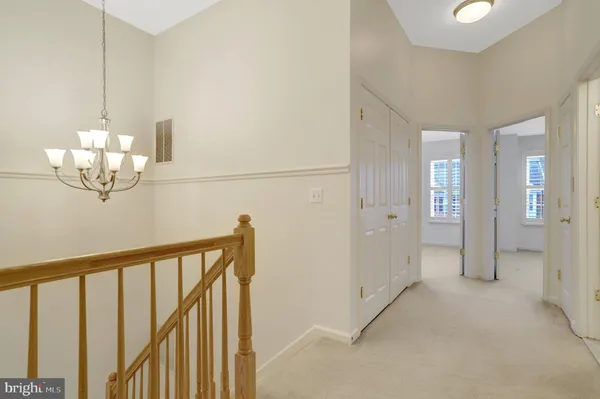 an empty room with closet and a chandelier fan