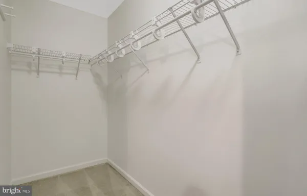 an empty room with a fan & a ceiling fan