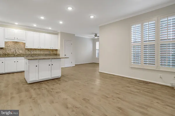 a open kitchen with white cabinets and stainless steel appliances