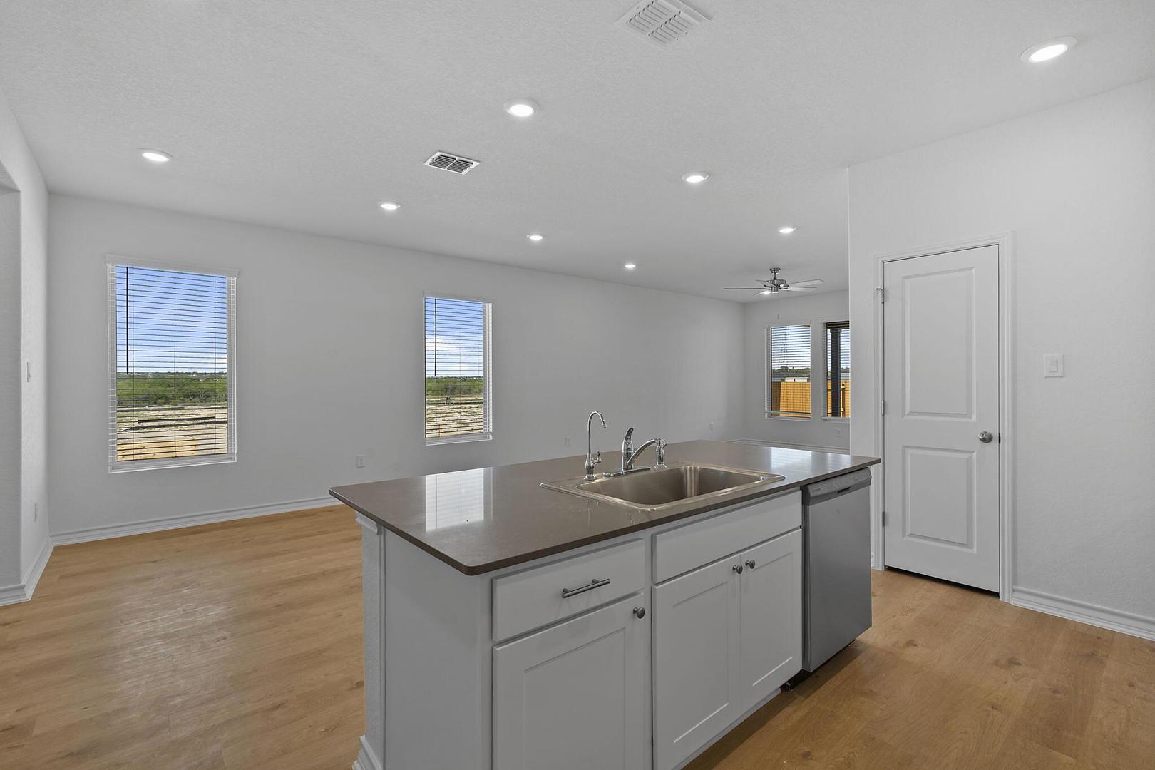 A well-appointed kitchen island with integrated sink anchors this bright, open-concept living space.