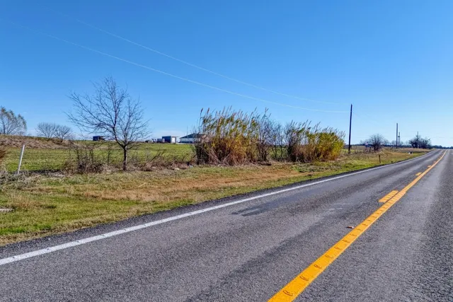 a view of a yard with wooden fence