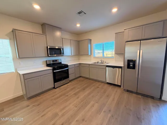 a kitchen with stainless steel appliances a refrigerator sink and microwave