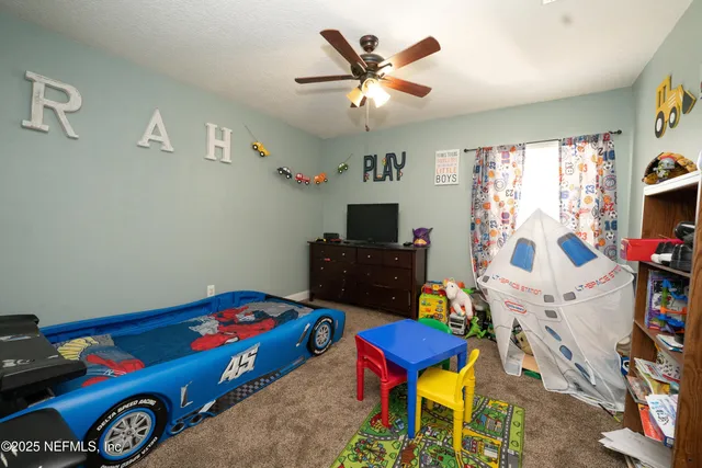 a bedroom with furniture and a flat screen tv