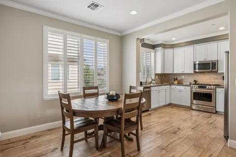 a kitchen with a stove a sink a microwave and a dining table