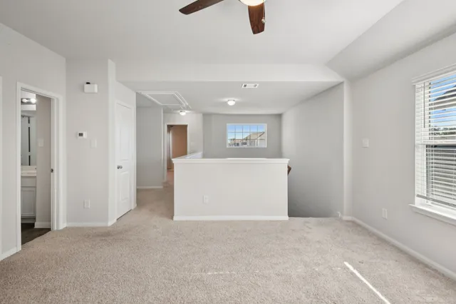a view of a livingroom with a ceiling fan and window