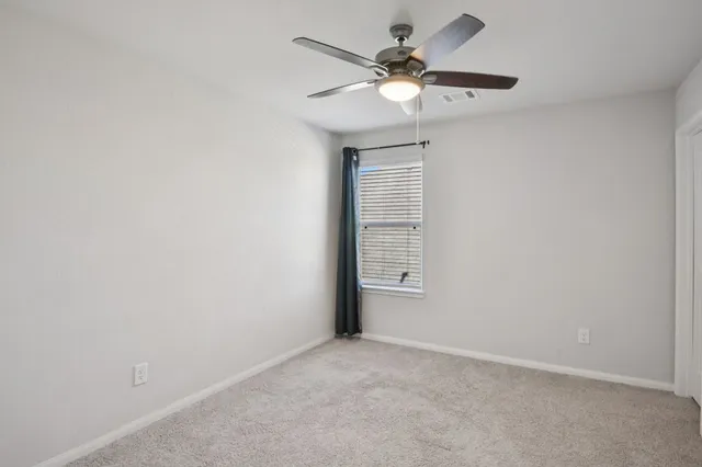 an empty room with a fan and a ceiling fan