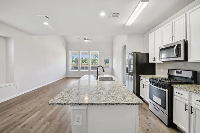 a kitchen with granite countertop a stove and a refrigerator