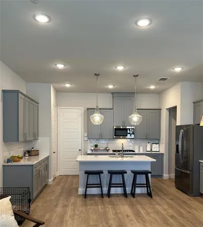 a large kitchen with a table and chairs