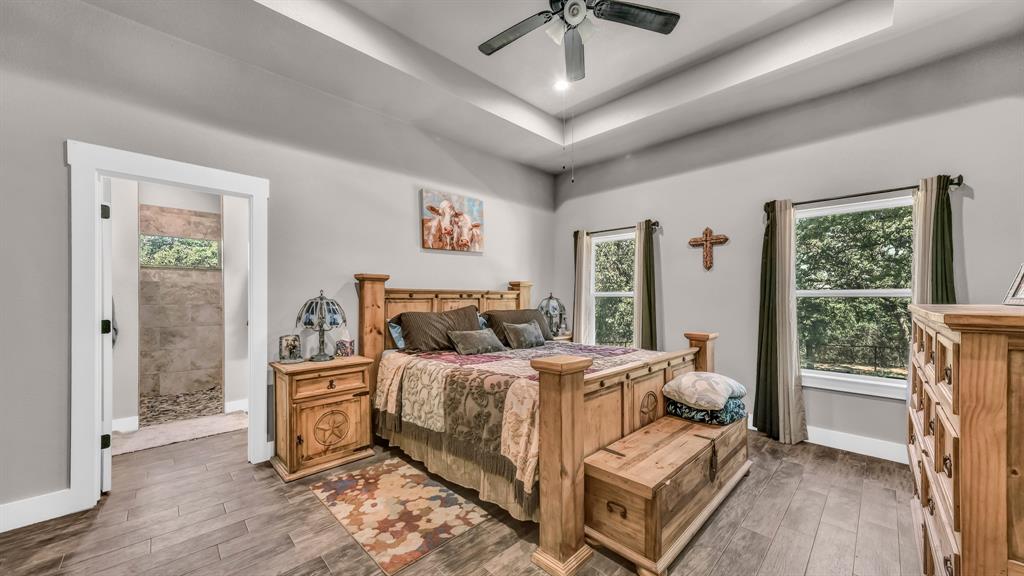 143 Oak Tree Drive Poolville, TX 76487 - Photo 18 of 40 a bedroom with a bed and wooden floor