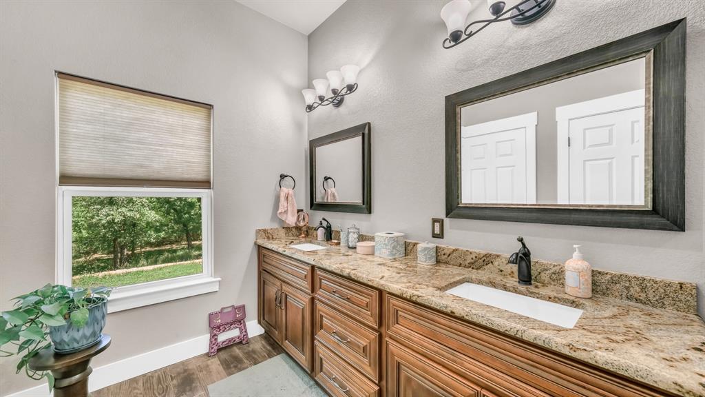 143 Oak Tree Drive Poolville, TX 76487 - Photo 20 of 40 a bathroom with a granite countertop sink a large mirror and a window