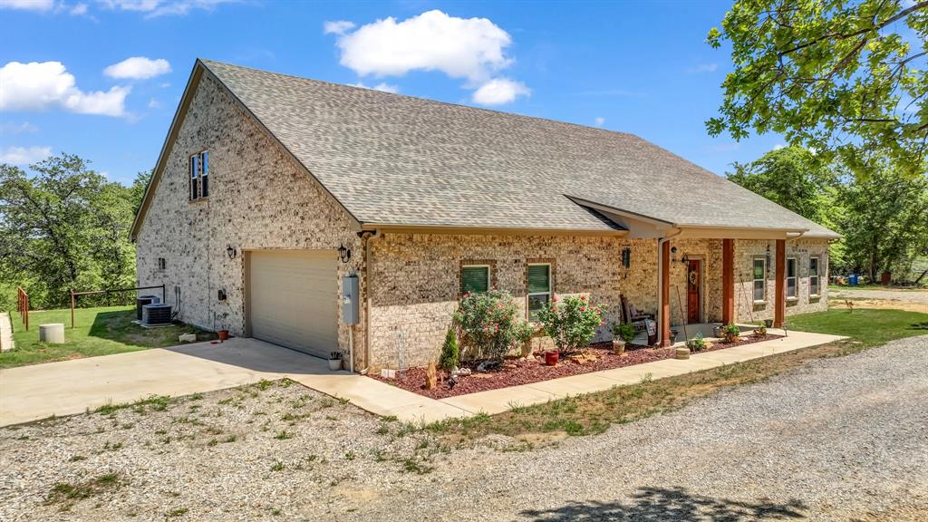 143 Oak Tree Drive Poolville, TX 76487 - Photo 2 of 40 a front view of a house with a yard